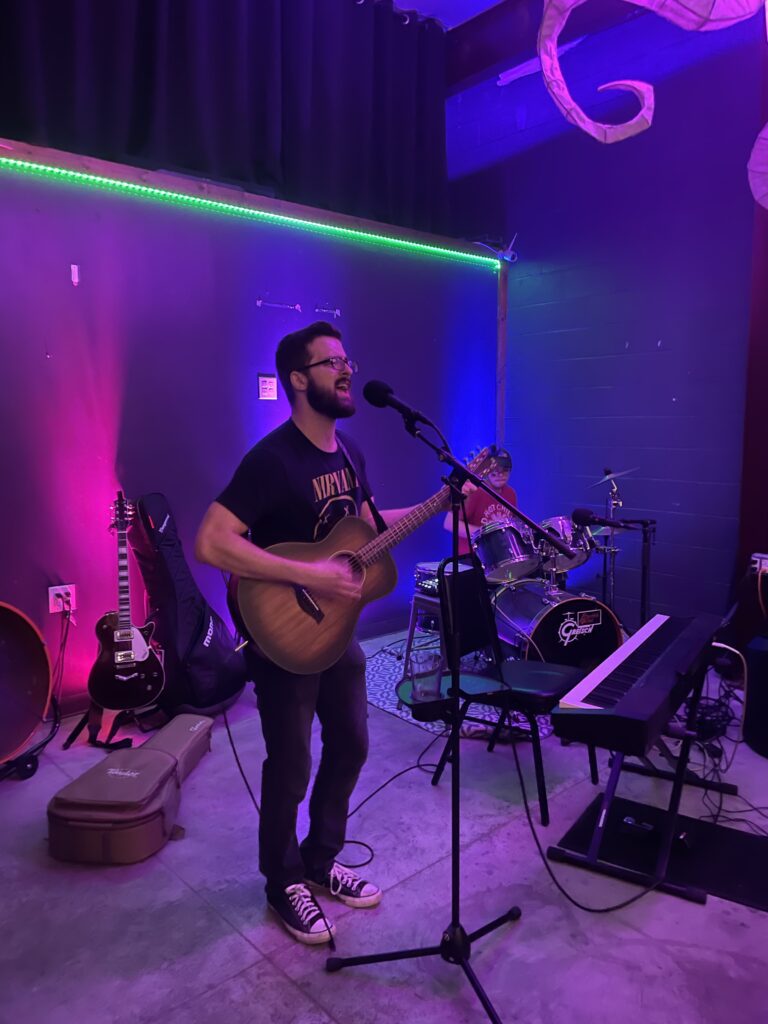 Josh from Cigarette Trees playing the acoustic guitar and singing at The Void Sake in Lexington, Ky